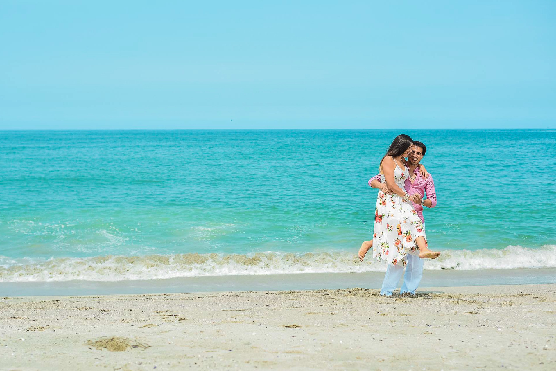Pareja abrazándose en la orilla durante una sesión de preboda