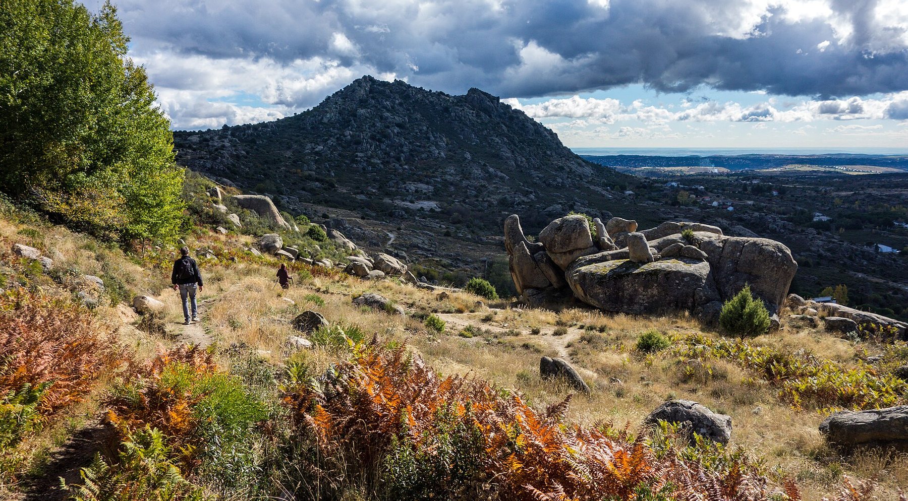 El valle de la Sierra Norte de Madrid desde La Cabrera, con roca de granito y helechos